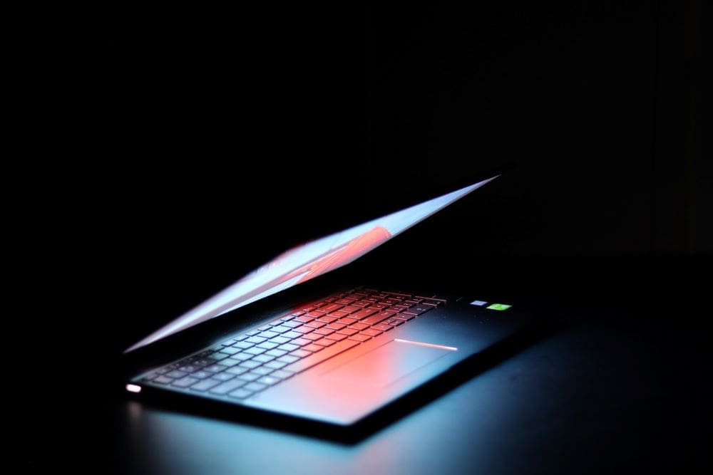 A Lenovo computer with a bright display on a dark background.