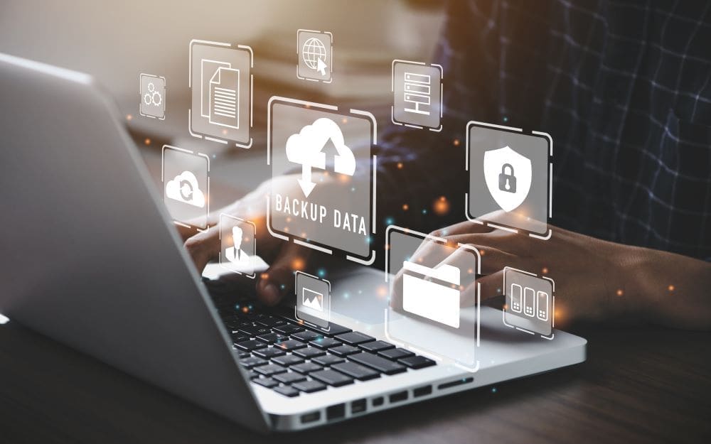 A computer technician backing up client data on an Apple computer.