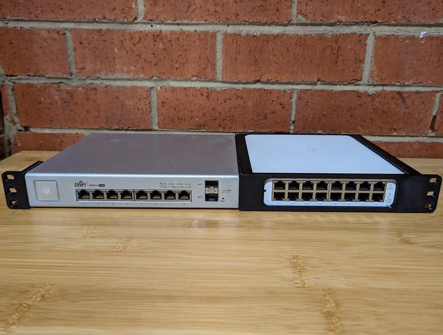 Two network switches on wooden surface.