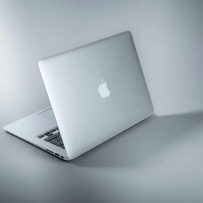 AppleRepairCaliComp An apple computer on display on a plain gray background.